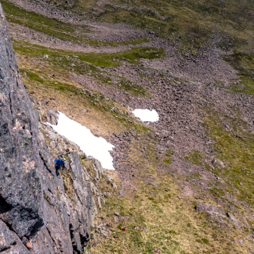 Looking down on a climber on the first pitch of the rock climb called Amethyst Pillar in Coire Sputan Dearg in the Cairngorms in sunny weather