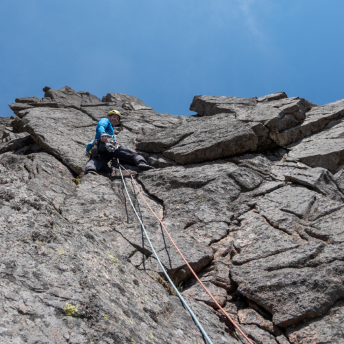 Looking up at a climber on the second pitch of the rock climb called Amethyst Pillar in Coire Sputan Dearg in the Cairngorms in sunny weather